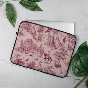 Op de afbeelding: Een rechthoekige laptophoes met een oudroze achtergrond en een donkerbordeauxrood toile de jouy-patroon. De print toont scènes in 18e-eeuwse stijl met een groot landhuis, figuren in historische kleding, paarden en diverse bomen.