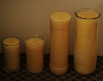 May include: Four yellow beeswax candles of varying sizes in glass jars. The candles are arranged from smallest to largest.