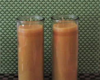 May include: Two clear glass candle holders with a golden yellow candle inside each. The candles are in a textured glass holder.