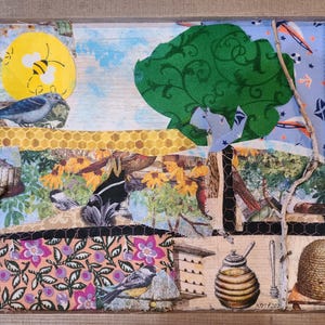 May include: A framed collage of various images, including a bee, birds, flowers, and a honeycomb. The collage is made of different materials, including fabric, paper, and wood. The frame is made of wood and has a rustic finish.