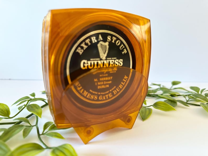 Peut inclure: Un ensemble de dessous de verre Guinness ambr&eacute;s avec le logo Guinness Extra Stout. Les dessous de verre sont dans un support de couleur ambre assortie. Le support et les dessous de verre sont en plastique transparent.