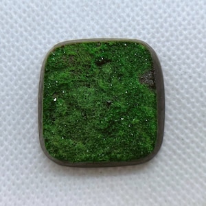 Natural Uvarovite (Green Garnet) cabochon with crystals on top from Ural Mountain, Russia. Crystals are on Chromite matrix.