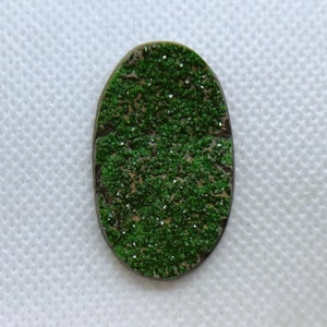 Natural Uvarovite (Green Garnet) cabochon with crystals on top from Ural Mountain, Russia. Crystals are on Chromite matrix.