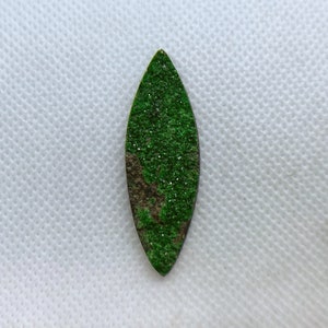 Natural Uvarovite (Green Garnet) cabochon with crystals on top from Ural Mountain, Russia. Crystals are on Chromite matrix.