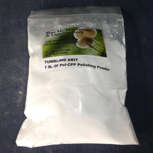 May include: A white plastic bag filled with white powder labeled "TUMBLING GRIT 1 lb. Of Pol-CPP Polishing Powder" with a sticker on the front that says "Blue Mt. Mushrooms & Lapidary Rock 2301 East La Grande, OR 97830 Phone: 541-910-0406 ID # 46-2162803"