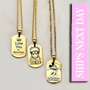 May include: Three gold-toned metal dog tag pendants on matching link chains. The first tag reads "We Love You" with "Mon + Dad". The second features an anime character illustration above the name "RENE". The third shows a cartoon mouse above "ROCKY".