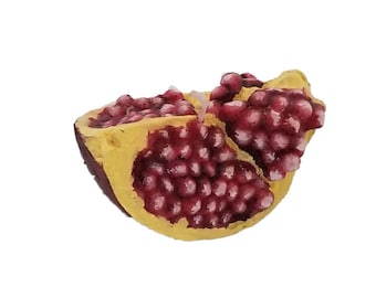 Handgemaakte kaars in de vorm van een granaatappelschijfje: realistische fruitvorm
