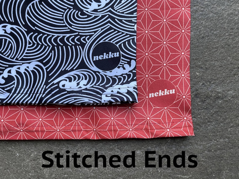May include: Two fabric panels with stitched edges. The top panel is black with a white wave pattern and the text "nekku". The bottom panel is red with a white geometric pattern and the text "nekku".