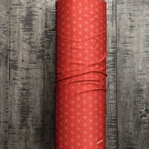 May include: Red fabric tube with a white geometric pattern and the word "nekku" printed on the bottom.