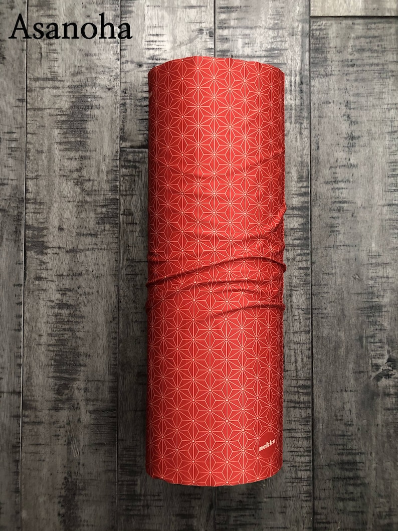 May include: Red fabric tube with a white geometric pattern and the word "nekku" printed on the bottom.