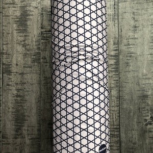 May include: A white and black patterned neck gaiter with a black circle logo that says "nekkn".
