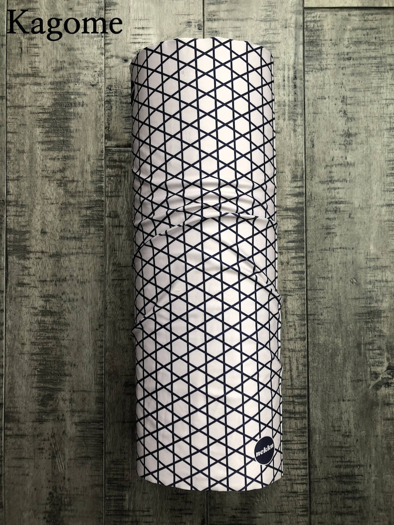 May include: A white and black patterned neck gaiter with a black circle logo that says "nekkn".