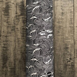 May include: Black and white fabric with a wave pattern. The fabric is rolled up and the label "nekku" is visible.