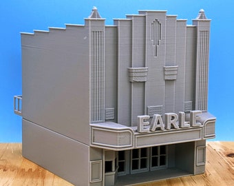 Puede incluir: Modelo gris impreso en 3D del Teatro Earle, con detalles arquitectónicos Art Déco. El modelo incluye el nombre del teatro, Earle, sobre la entrada. El edificio tiene una línea de techo escalonada y detalles verticales.