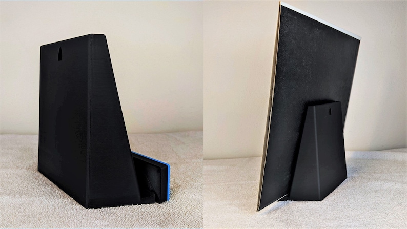May include: A black plastic stand with a triangular base and a rectangular back panel. The stand has a small hole in the back panel for hanging. The stand is designed to hold a picture or other object.