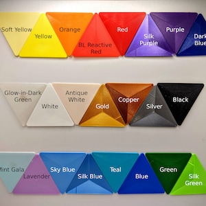 May include: A collection of 20 triangle-shaped plastic samples in various colors, including soft yellow, orange, red, purple, dark blue, glow-in-dark green, antique white, copper, black, white, gold, silver, mint gala, lavender, sky blue, teal, blue, and green. The samples are arranged in three rows.