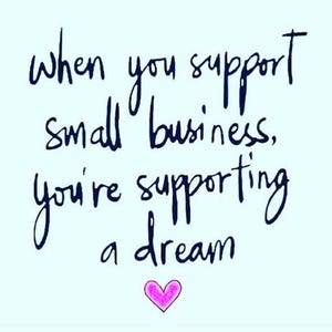 May include: A light blue square graphic featuring dark blue handwritten text that reads, "When you support small business, you're supporting a dream." Below the text is a small, simple pink heart illustration with a dark outline.