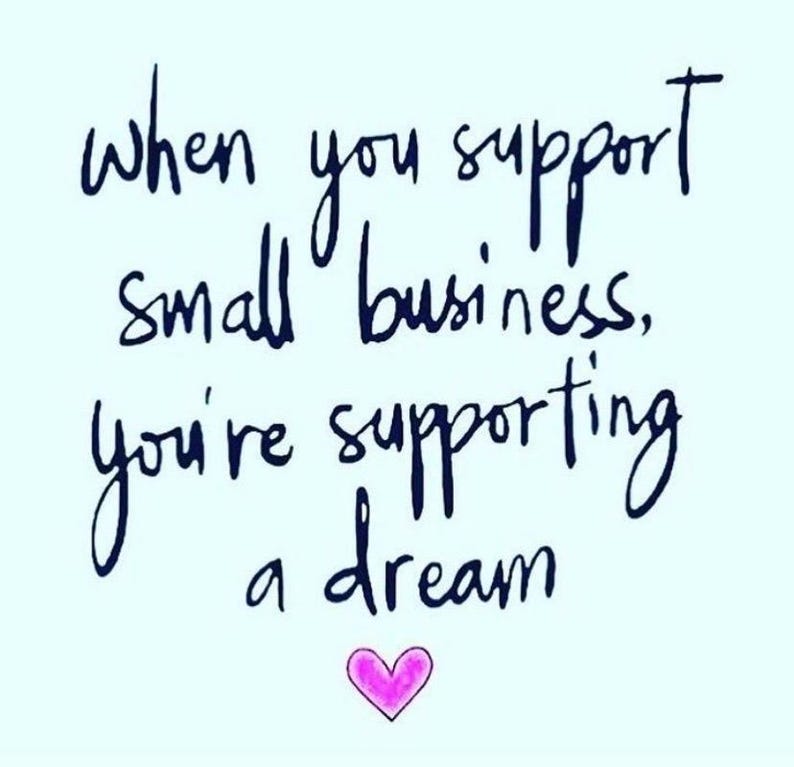May include: A light blue square graphic featuring dark blue handwritten text that reads, "When you support small business, you're supporting a dream." Below the text is a small, simple pink heart illustration with a dark outline.