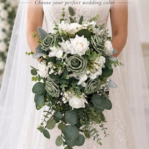 Op de afbeelding: Een waterval bruidsboeket met saliegroene en witte rozen, geaccentueerd met eucalyptusbladeren en kleine witte vulbloemen. De tekst CUSTOM ROSE COLORS AVAILABLE en Choose your perfect wedding color staat hierboven weergegeven.