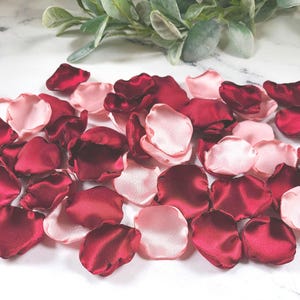 A mix of burgundy and blush pink rose petals for flower girl petals, baskets, and memory or reception table scatter, backdrop accents, bridal shower decor. For the future bride planning a classic wedding ceremony or fall bridal brunch event.