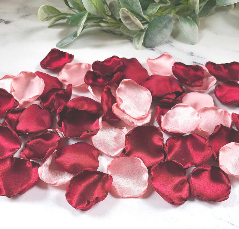 A mix of burgundy and blush pink rose petals for flower girl petals, baskets, and memory or reception table scatter, backdrop accents, bridal shower decor. For the future bride planning a classic wedding ceremony or fall bridal brunch event.