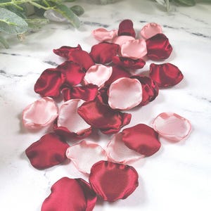 A mix of burgundy and blush pink rose petals for flower girl petals, baskets, and memory or reception table scatter, backdrop accents, bridal shower decor. For the future bride planning a classic wedding ceremony or fall bridal brunch event.