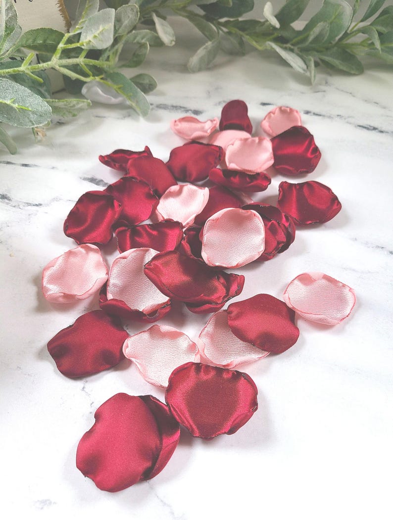 A mix of burgundy and blush pink rose petals for flower girl petals, baskets, and memory or reception table scatter, backdrop accents, bridal shower decor. For the future bride planning a classic wedding ceremony or fall bridal brunch event.