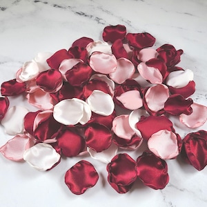 A mix of burgundy, ivory, and blush pink rose petals for flower girl petals, baskets, and memory or reception table scatter, backdrop accents, bridal shower decor. For the future bride planning a classic wedding ceremony or fall bridal brunch event.
