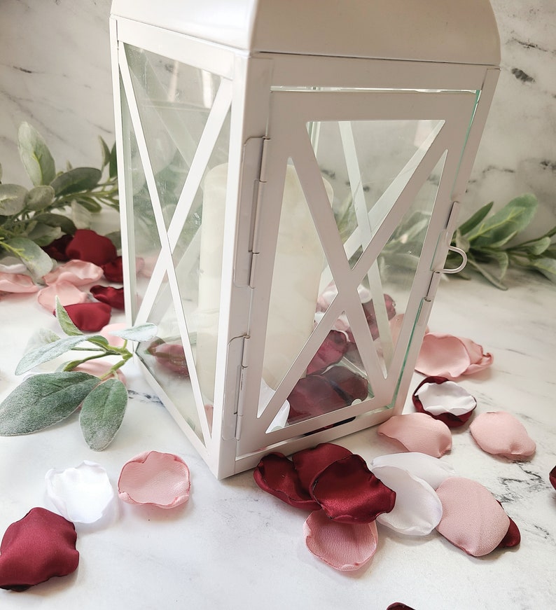 A mix of burgundy, ivory, and blush pink rose petals sprinkled around lantern, for flower girl petals, baskets, and memory or reception table scatter, backdrop accents, bridal shower decor. For the future bride planning a classic or boho wedding ceremony or fall bridal brunch event.