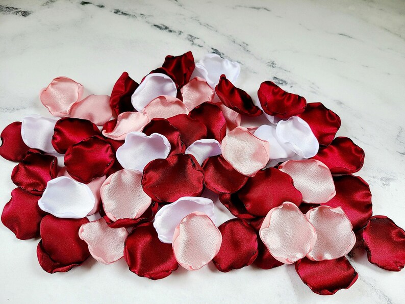 A mix of burgundy, white, and blush pink rose petals for flower girl petals, baskets, memory or reception table scatter, backdrop accents, bridal shower decor. For the future bride planning a classic wedding ceremony or fall bridal brunch event.