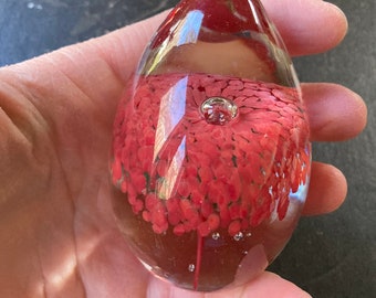 Beautiful egg-shaped glass paperweight with red flower and bubble