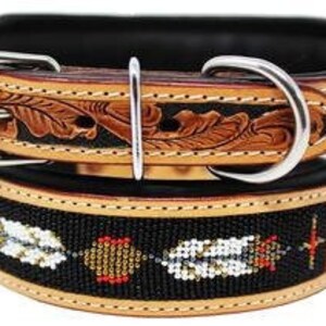 May include: A brown leather dog collar with a black beaded trim and a floral design. The collar has a silver buckle and is decorated with white feathers.