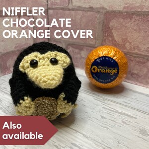 K&ouml;nnte beinhalten: H&auml;keltier Niffler, das eine Schokoladenorange h&auml;lt. Die Orange ist in Folie verpackt und tr&auml;gt die Aufschrift "Terry's Chocolate Orange" mit "Made with Real Orange Oil".