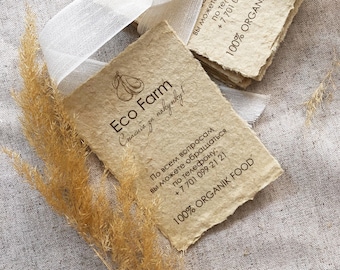 以下が含まれることがあります： 梨のロゴと「Eco Farm」と「100% Organik Food」の文字が書かれた茶色の紙のカードの束。カードには「Спасибо за покупку!」の文字も書かれている。カードは白いリボンで結ばれている。