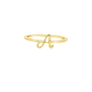 Puede incluir: Un anillo de oro con una letra 'A' en cursiva.