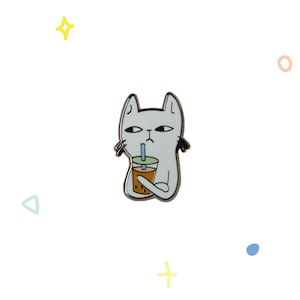 Pode incluir: Um gato branco com olhos pretos e nariz preto está segurando uma xícara marrom com um canudo azul e uma tampa verde. O gato está olhando para a xícara. O gato está em um fundo branco.