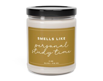 May include: A 9 oz candle in a clear glass jar with a black lid. The label is gold with the text "Smells Like Personal Study Time" and "Olive + Fig Co."
