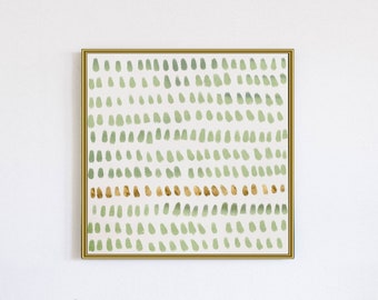 May include: A framed abstract art print with a green and gold pattern. The print features a series of small, green dots arranged in rows, with a single row of gold dots running horizontally across the center.