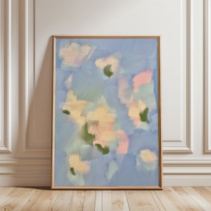 Op de afbeelding: Abstract schilderij in een houten lijst. Het schilderij heeft een blauwe achtergrond met zachte, pastelkleurige vormen in tinten roze, geel en groen.