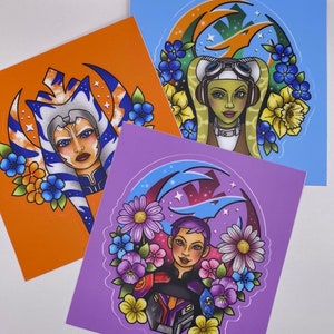 May include: Three colorful illustrations of female characters from the Star Wars universe. Each illustration features a different character with a unique hairstyle and outfit, surrounded by flowers and a stylized background.