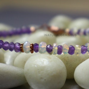 May include: A delicate bracelet featuring alternating purple amethyst and iridescent opal beads. The bracelet is strung on a thin, flexible cord and has a copper-colored clasp. The text "NATURALGEMSHUB" is visible in the background.