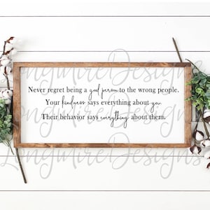 May include: A wooden sign with a white background and a brown frame. The sign has a quote that reads: "Never regret being a good person to the wrong people. Your kindness says everything about you. Their behavior says everything about them."