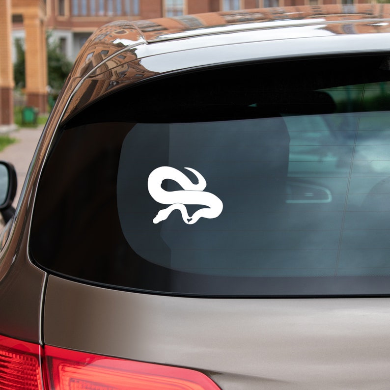 以下が含まれることがあります： 車のリアウィンドウに巻かれたヘビの白いビニールステッカー