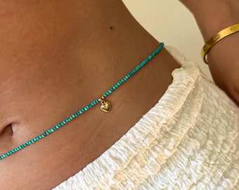 May include: A turquoise beaded waist chain with a gold heart charm.