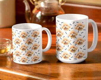 May include: Two white ceramic mugs with a pattern of a brown dog's face and blue bone shapes. The mugs are on a wooden surface.
