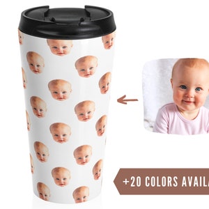 May include: White travel mug with a repeating pattern of a baby's face. The mug has a black lid and a brown text label that says " +20 COLORS AVAILABLE".