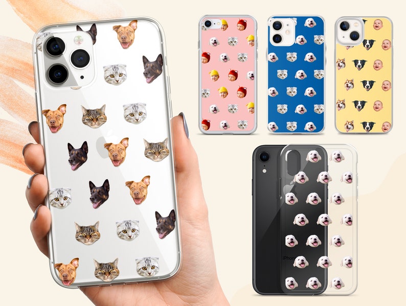 May include: A clear phone case with a repeating pattern of cat and dog faces. The case is shown on a hand holding it. There are other phone cases in the background with different patterns.