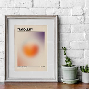 May include: A framed print with a blurred orange and purple gradient design. The print has the text "TRANQUILITY" and "STATE OF MIND SERIES" at the top and bottom.