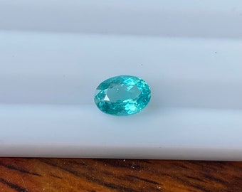May include: A light blue oval-shaped gemstone with a slight green hue.