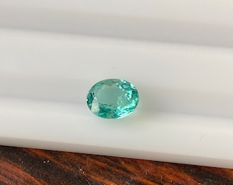 May include: A light blue oval-shaped gemstone with a faceted cut.
